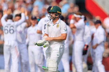 Dean Elgar of South Africa walks back to the pavilion as he is clean bowled by James Anderson of England for 11 runs