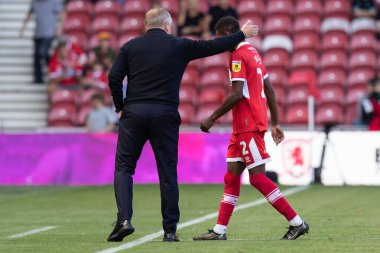 Chris Wilder manager of Middlesbrough shepherds Isaiah Jones #2 off the field at half time 