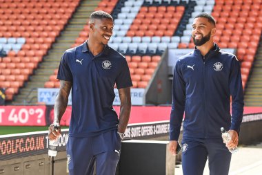 Marvin Ekpiteta #21 and CJ Hamilton #22 of Blackpool arrive at Bloomfield Road