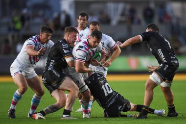 Magnus Bradbury of Bristol Bears tackled on JJ Hanrahan of Dragons Rugby and Jack Dixon of Dragons Rugby, 