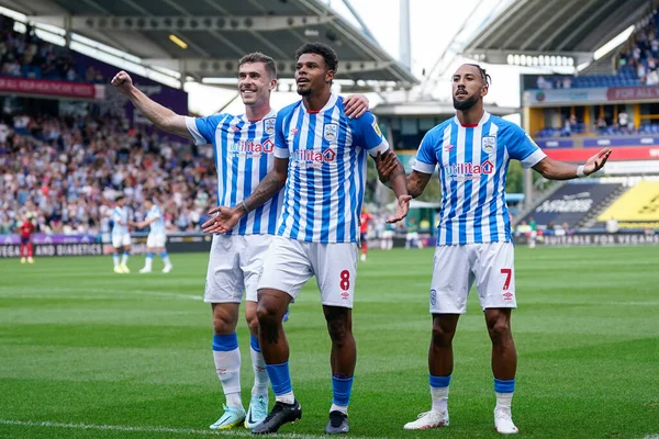 Tino Anjorin #8 of Huddersfield Town celebrates with Sorba Thomas and Josh Ruffels