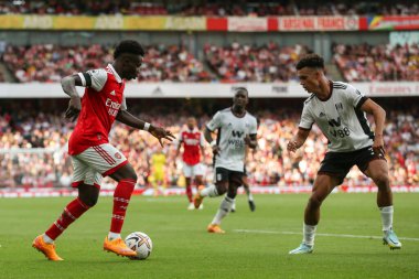 Bukayo Saka #7 of Arsenal runs at Antonee Robinson #33 of Fulham 