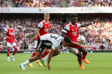 Bukayo Saka #7 of Arsenal and Antonee Robinson #33 of Fulham tussle for the ball