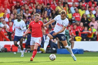 Harry Kane #10 of Tottenham Hotspur holds the ball as Lewis O'Brien #14 of Nottingham Forest pressures 