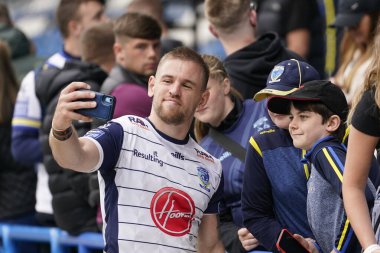 Matt Dufty #36 of Warrington Wolves takes a selfie with some young Wire fans after the match