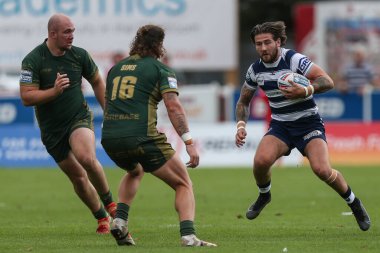 Joe Shorrocks #22 of Wigan Warriors runs at Korbin Sims #16 of Hull KR  