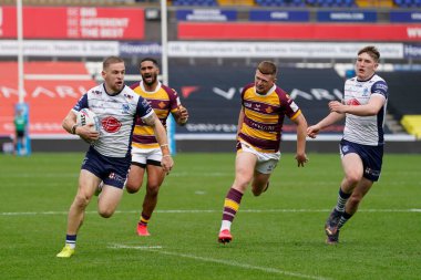Matt Dufty #36 of Warrington Wolves breaks through Huddersfield Giants defence to score a try