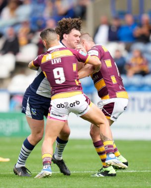 Rob Mulhern #19 of Warrington Wolves runs at Danny Levi #9 of Huddersfield Giants