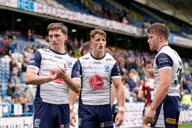 Adam Holroyd, Josh Lynch and Luke Thomas of Warrington Wolves applaud the travelling Wire fans after the match 