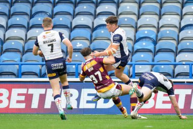 Toby King #37 of Huddersfield Giants strips the ball from Josh Thewlis #22 of Warrington Wolves from a kick to score a try 