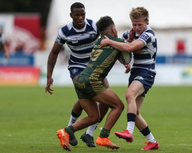Phoenix Laulu-Togaga'e #29 of Hull KR is tackled by Logan Astley #34 of wigan Warriors