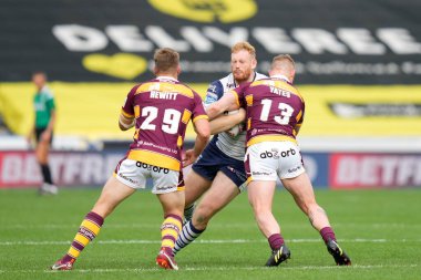 Joe Bullock #15 of Warrington Wolves runs at Sam Hewitt #29 and Luke Yates of Huddersfield Giants