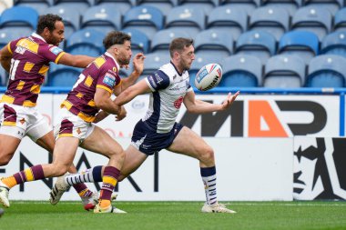 Jake Wardle #34 of Warrington Wolves juggles the ball as he crosses the try line to score 