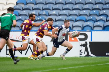 Jake Wardle #34 of Warrington Wolves juggles the ball as he crosses the try line to score 