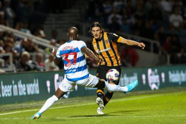 Alfie Jones 5 of Hull City passes the ball under pressure from Albert Adomah #37 of QPR 