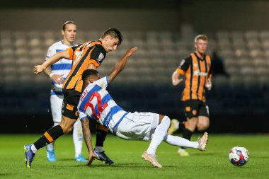 Ryan Longman #16 of Hull City piles Kenneth Paal #22 of QPR to the ground 