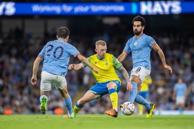 Lewis O'Brien #14 of Nottingham Forest looks to get beyond Bernado Silva #20 of Manchester City and Ilkay Gundogan #8 of Manchester City