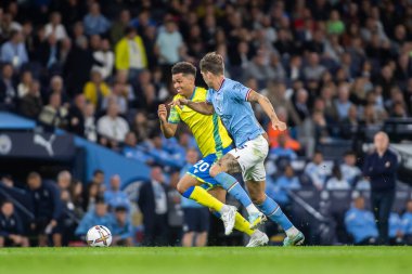 Brennan Johnson #20 of Nottingham Forest looks to close in on John Stones #5 of Manchester City