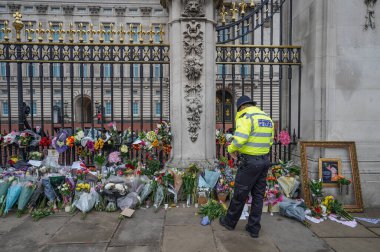 Bir polis memuru, 9 Eylül 202 'de İngiltere Buckingham Sarayı' nda Kraliçe 'nin vefatının ardından yas tutanlar taziyelerini sunarken taziyelerini bildirir.