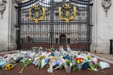 Yas tutanlar, Majesteleri Kraliçe 'nin 9 Eylül 202' de Buckingham Sarayı 'nda vefat etmesinden sonra saygılarını sunarken, çiçeklerini Mekan kapılarına bırakırlar.