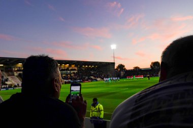 Bir Sheffield Wednesday taraftarı, HRH Kraliçesi 2. Elizabeth 'in Çarşamba günü Morecambe - Sheffield maçı sırasında Morecambe, United Kin' deki Mazuma Stadyumu 'nda ölmesinin ardından saygı göstergesi olarak bir dakika saygı duruşunda bulunurken fotoğraf çekiyor.