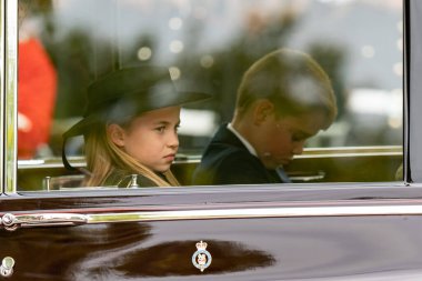 Galler Prensesi Charlotte ve Galler Prensi George Kraliçe Elizabeth 11 'in tabutunun geçit töreni sırasında Londra' daki Buckingham Sarayı 'na geri dönerler.