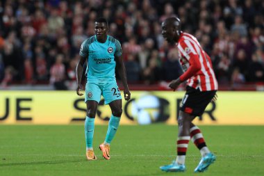 Brighton & Hove Albion 'dan 25 numaralı Moiss Caicedo Premier Lig karşılaşmasında Brentford, Brighton ve Hove Albion' a karşı Londra 'daki Brentford Stadyumu, 14 Ekim 2022' de oynanan karşılaşmada Brentford # 11 numaralı Yoane Wissa gölgesi.