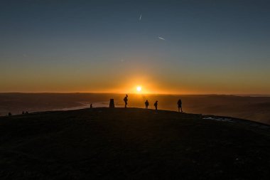 Sabah yürüyüşçüleri, 18 Ekim 202 'de Mam Tor, Peak District, İngiltere' de güneşin doğuşunu izlemek için Mam Tor 'un zirvesine giderler.