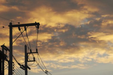Alacakaranlık 'ta Bulutlu Gökyüzü ile Yüksek Voltajlı Elektrik Kutuplarının Silueti