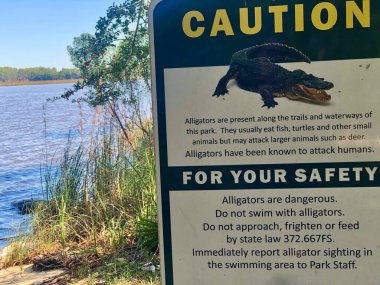 Bölgedeki timsah tehlikesi uyarısı için parkı imzalayın.