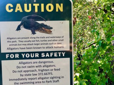 Bölgedeki timsah tehlikesi uyarısı için parkı imzalayın.