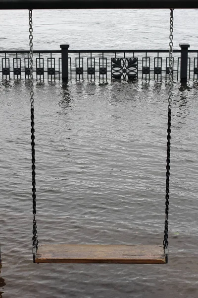 Krasnoyarsk. Flooding in the spring of 2021. Swing on a flooded embankment. — Stock Photo, Image