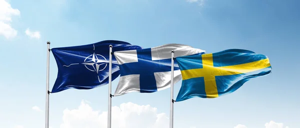 Flags of SWEDEN NATO AND FINLAND waving with cloudy blue sky background