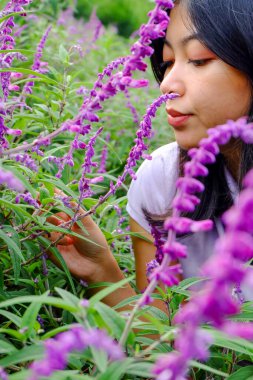 Parktaki lavanta çiçeklerinin kokusunu alan Asyalı güzel bir kadının seçici odağı. 