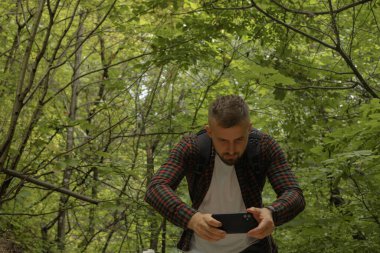 Ormanda telefonu olan bir adam.