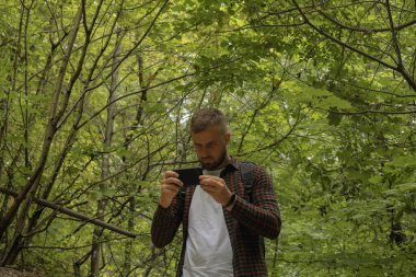 Ormanda telefonu olan bir adam.