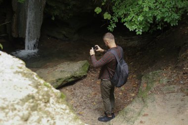 Ormanda telefonu olan bir adam.