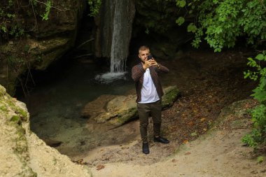 Ormanda telefonu olan bir adam.