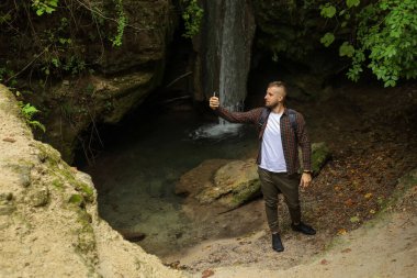 Ormanda telefonu olan bir adam.