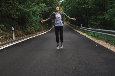 Güzel kız yol kenarındaki ormanda yürüyor.