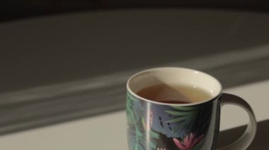 Beyaz bir masada bir fincan lezzetli aromatik sıcak çay standı.