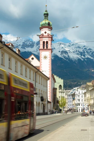 Innsbruck, Austra - April 17th 2018: A red coloured tram passing historic buildings of the city centre