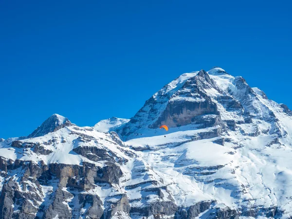 Een paraglider voor de beroemde Jungfrau berg, Zwitserland. — Stockfoto