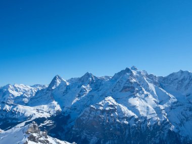 İsviçre 'nin Schilthorn tepesinden ünlü Eiger, Moench ve Jungfrau dağlarına doğru kış manzarası.