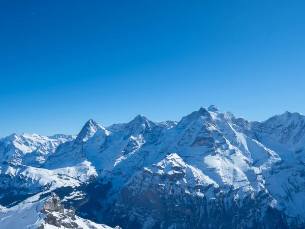 Zimní pohled z vrcholu Schilthorn, Švýcarsko, směrem k slavným horám Eiger, Moench, a Jungfrau — Stock fotografie