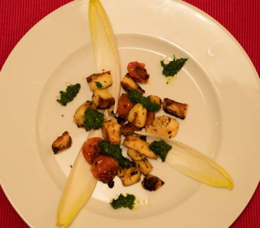 Vejetaryen ana yemeği: Izgara domatesli Topinambur, manouri peyniri ve maydanoz yağı, hindiba yapraklarıyla servis edilir..