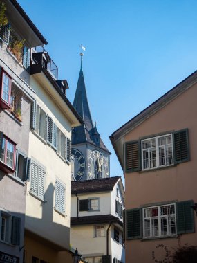 Zürih, İsviçre - 5 Mart 2022: Şehir merkezindeki tarihi cepheler ve St. Peter kilise kulesi.