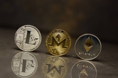  yansıtıcı yüzeyüzerinde altın monero gümüş litecoin ve ethereum standı