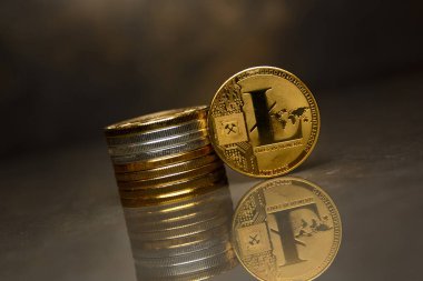 yansıtıcı yüzeyüzerinde altın Litecoin ve sikke yığını