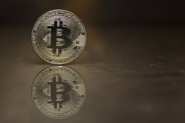  Altın Bitcoin aynalı arka planda duruyor